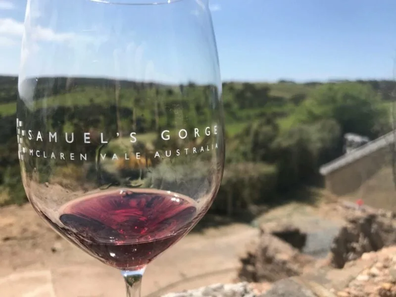 Looking through a glass of red wine to the Onkaparinga Gorge National Park beyond