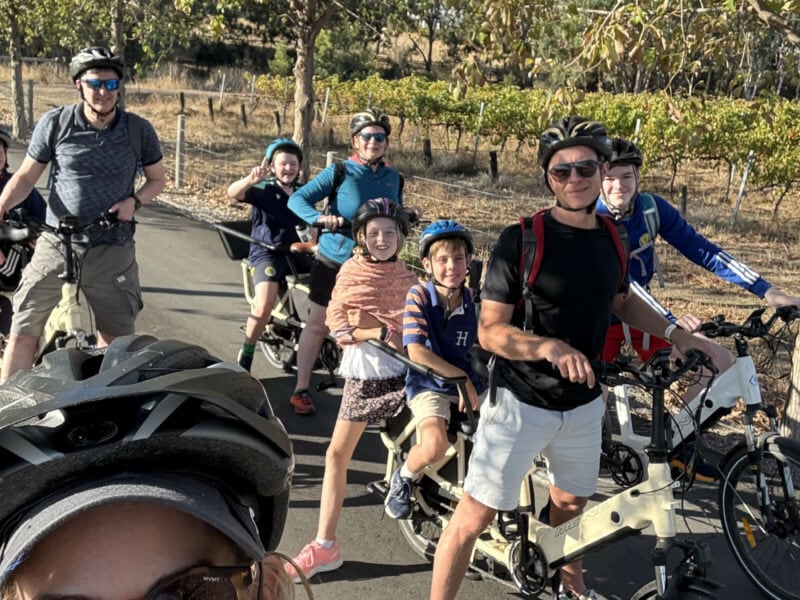 Four adults on cargo eBikes, with school aged children seated in the seats behind the adults