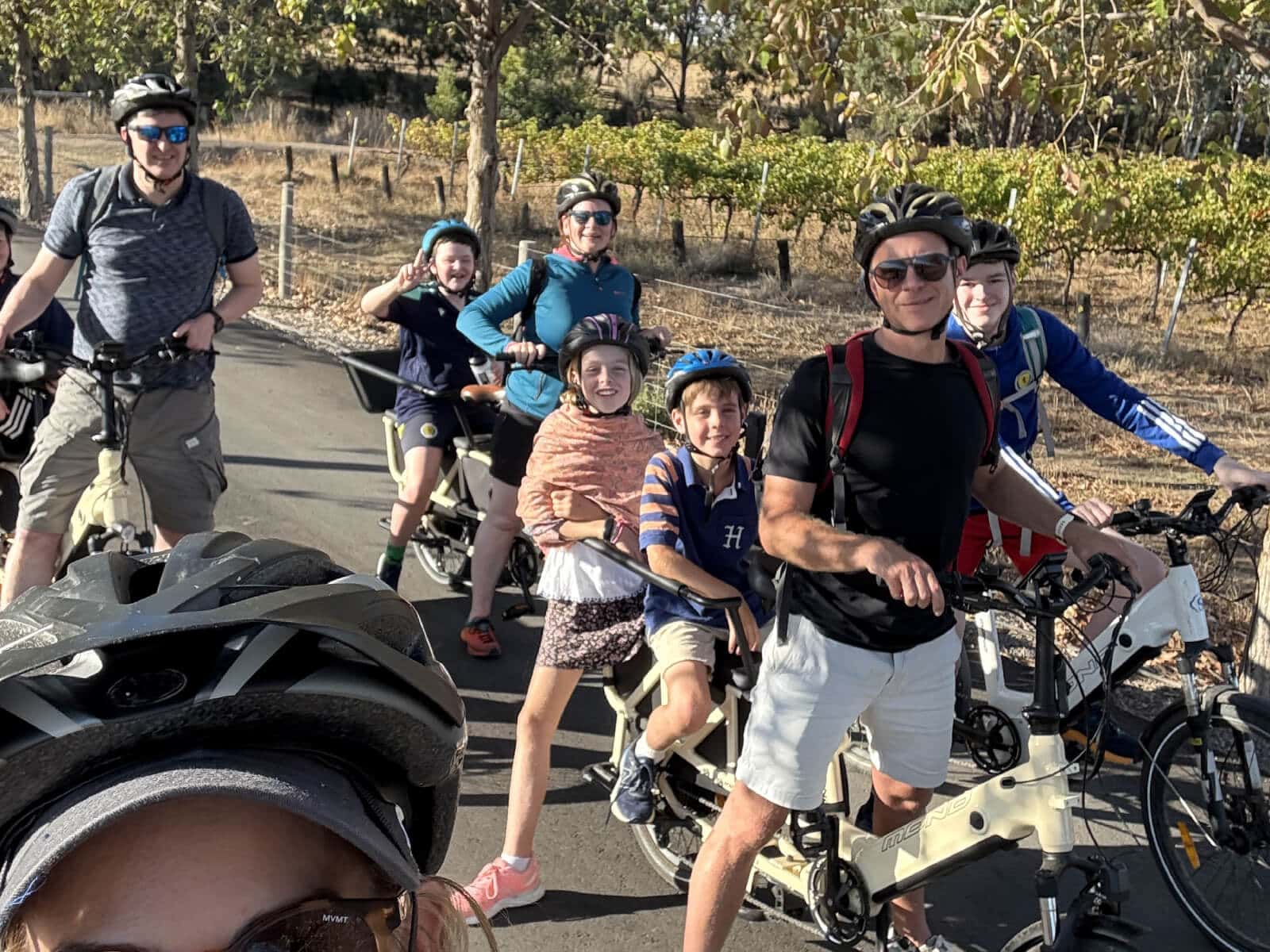Four adults on cargo eBikes, with school aged children seated in the seats behind the adults
