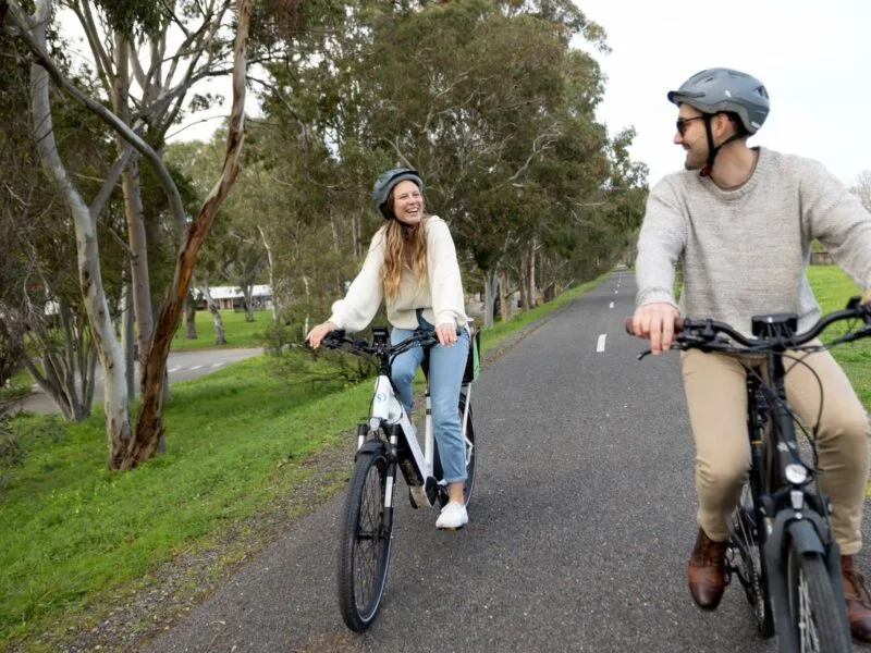 A man and a woman riding e-bikes on the Shiraz Trail in McLaren Vale
