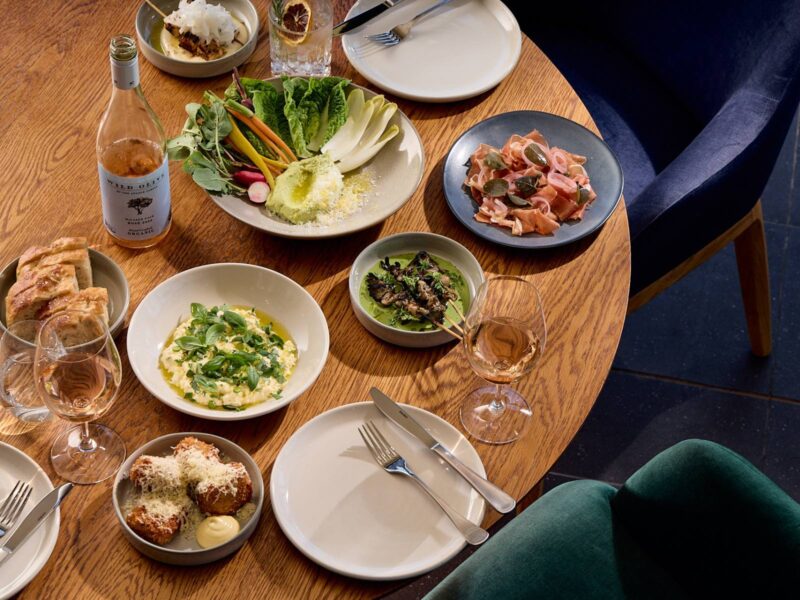 Plates of food and glasses of wine on table