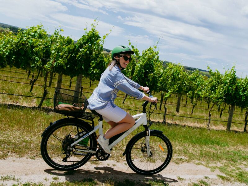 woman riding an eBike beside a vineyard