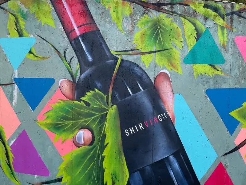 Mural of a bottle of Shirvington wine, painted on the side of a water tank