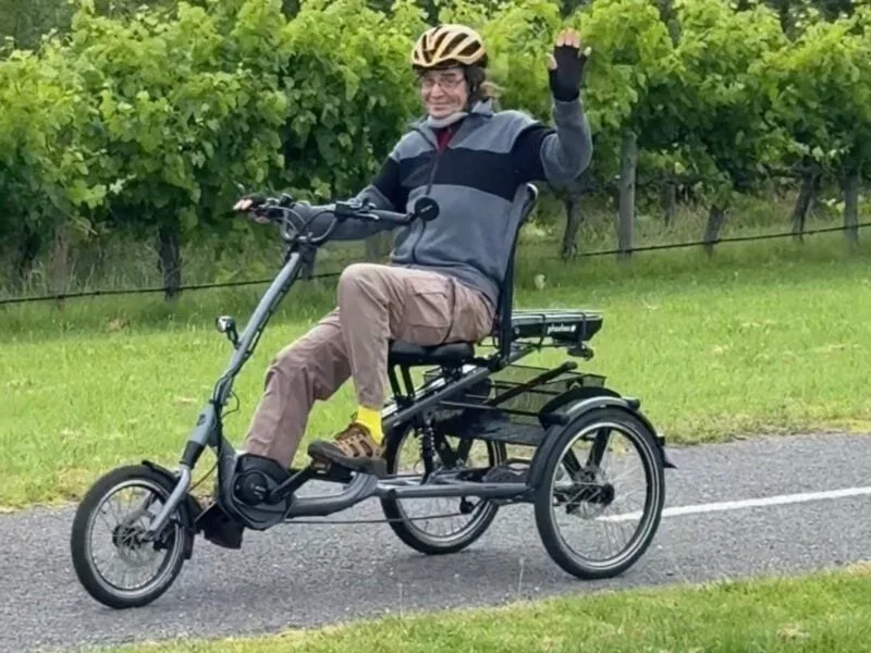 Low centre of gravity trike with rider wearing supportive neck brace