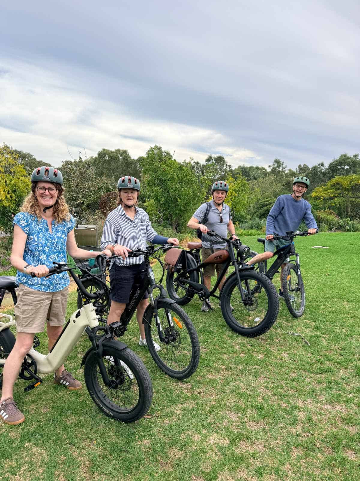 4 riders straddling 4 different styles of e-bikes on the lawns outside the McLaren Vale Visitor Information Centre
